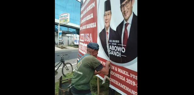 Seorang Kakek Jahit Kembali Baliho Prabowo-Sandi yang Robek